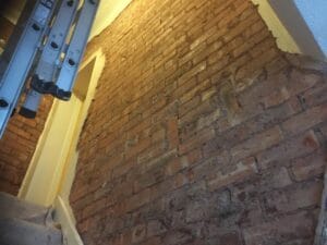 Internal wall stripped back to bare brick before installing XPS insulation panels.