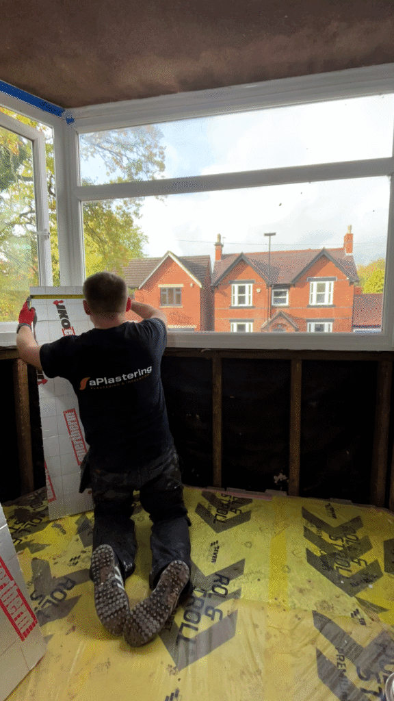 Installer fitting a PIR insulation panel inside a Sutton Coldfield property.