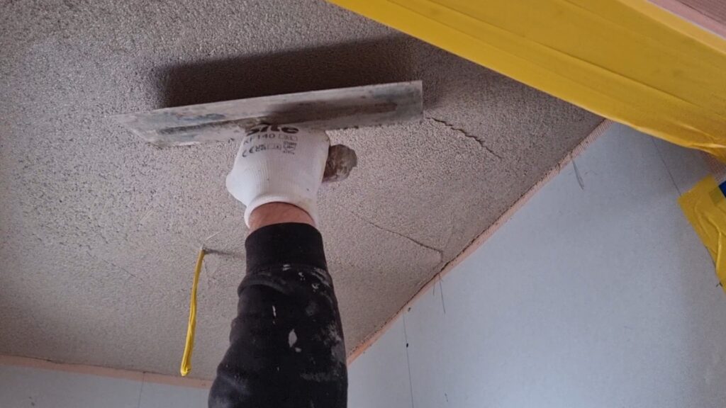 Trowel-applied cork coating on wall for improved thermal performance and reduced cold surfaces
