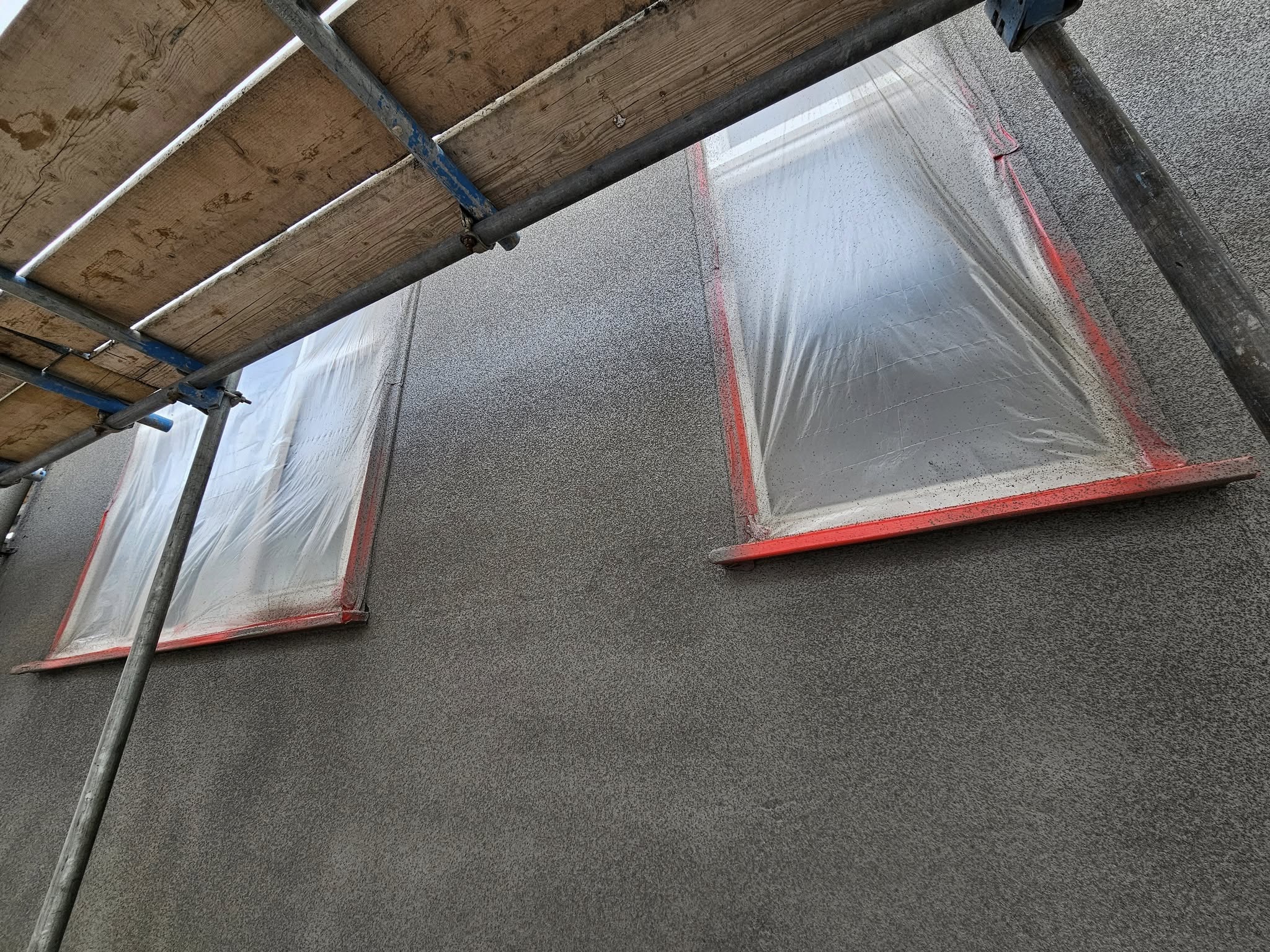 Grey spray cork applied to external walls for protection and modern finish