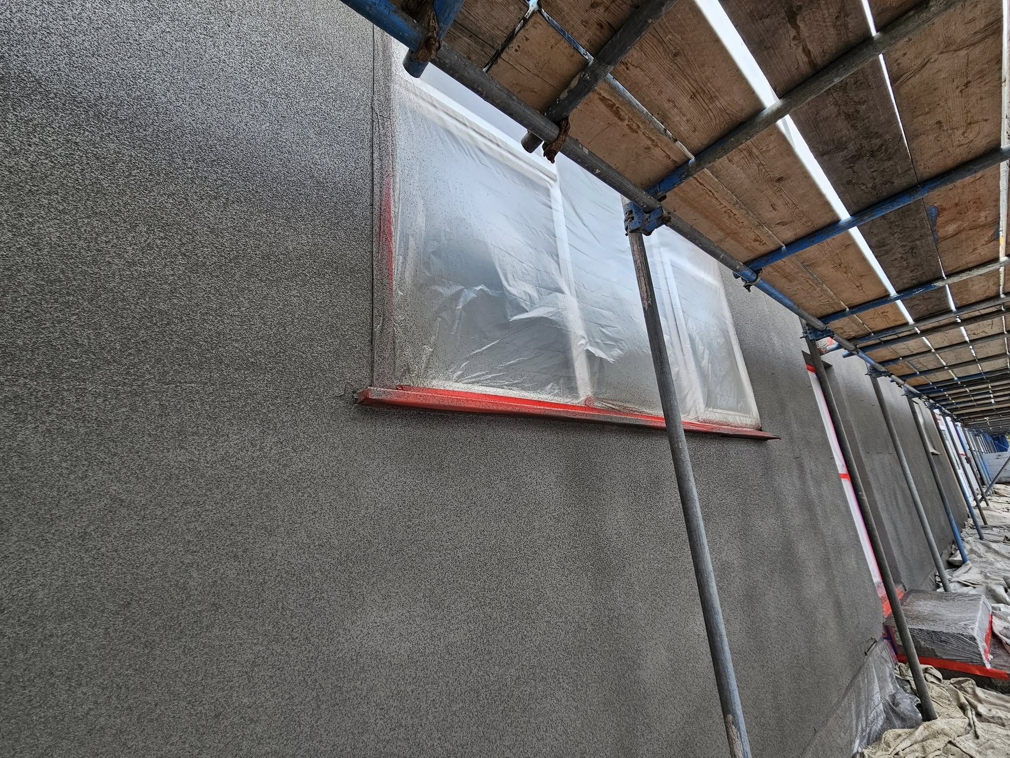 Grey spray cork applied to external walls for protection and modern finish