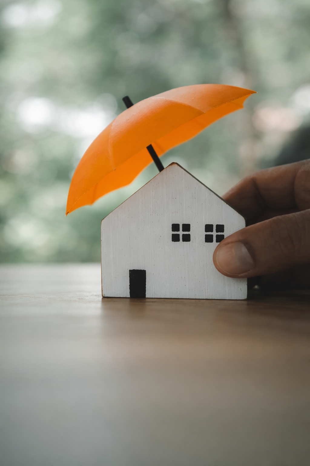 House under umbrella symbolising cork insulation protection against weather, cold and noise