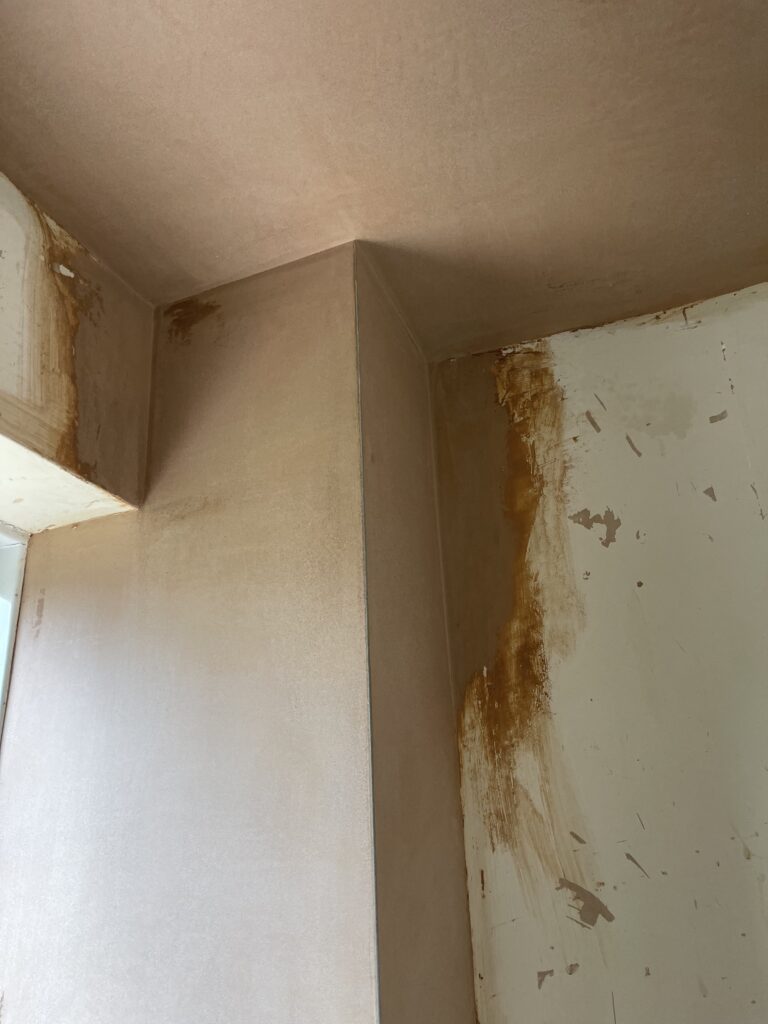 Wall repaired and patched with plaster ready for a smooth finish
