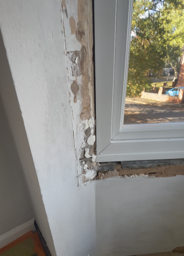 Air leaks around window on a solid brick wall causing heat loss and draughts